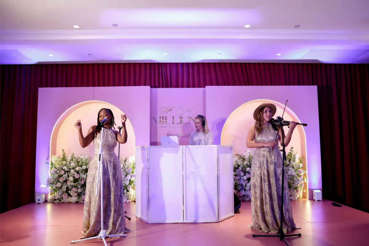Stage at Soft Girl Millions The Mastermind LIVE with branded backdrop and live performers